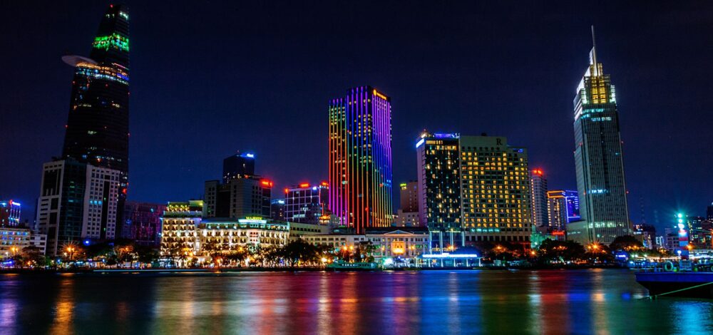 A modern cityscape of Ho Chi Minh City at night with glowing lights.