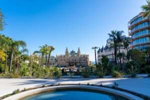 A view of the Monte Carlo Casino in Monaco with luxury cars parked in front.